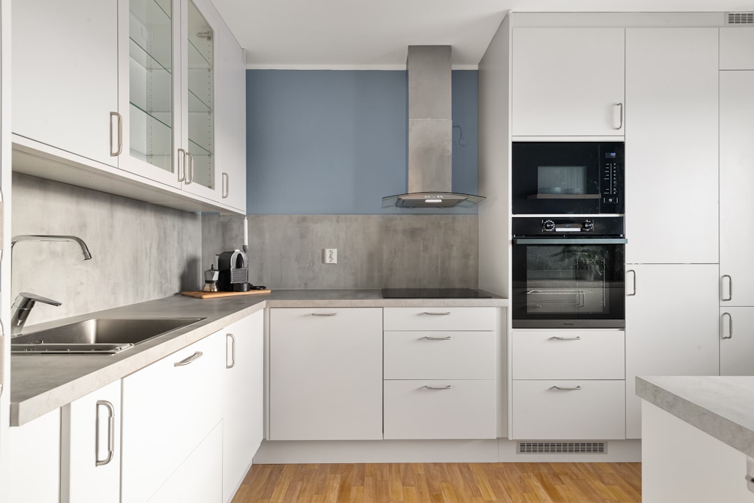 a-kitchen-with-white-cabinets-and-a-wooden-floor-edr-yzeqc9a